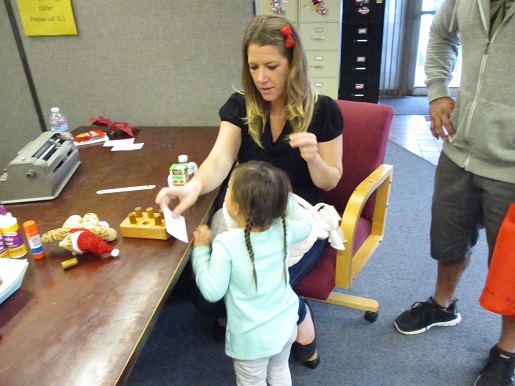 A mother and her blind child doing Braille